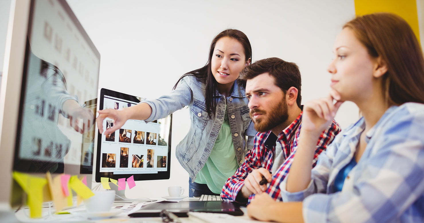 three people in a meeting looking at a computer