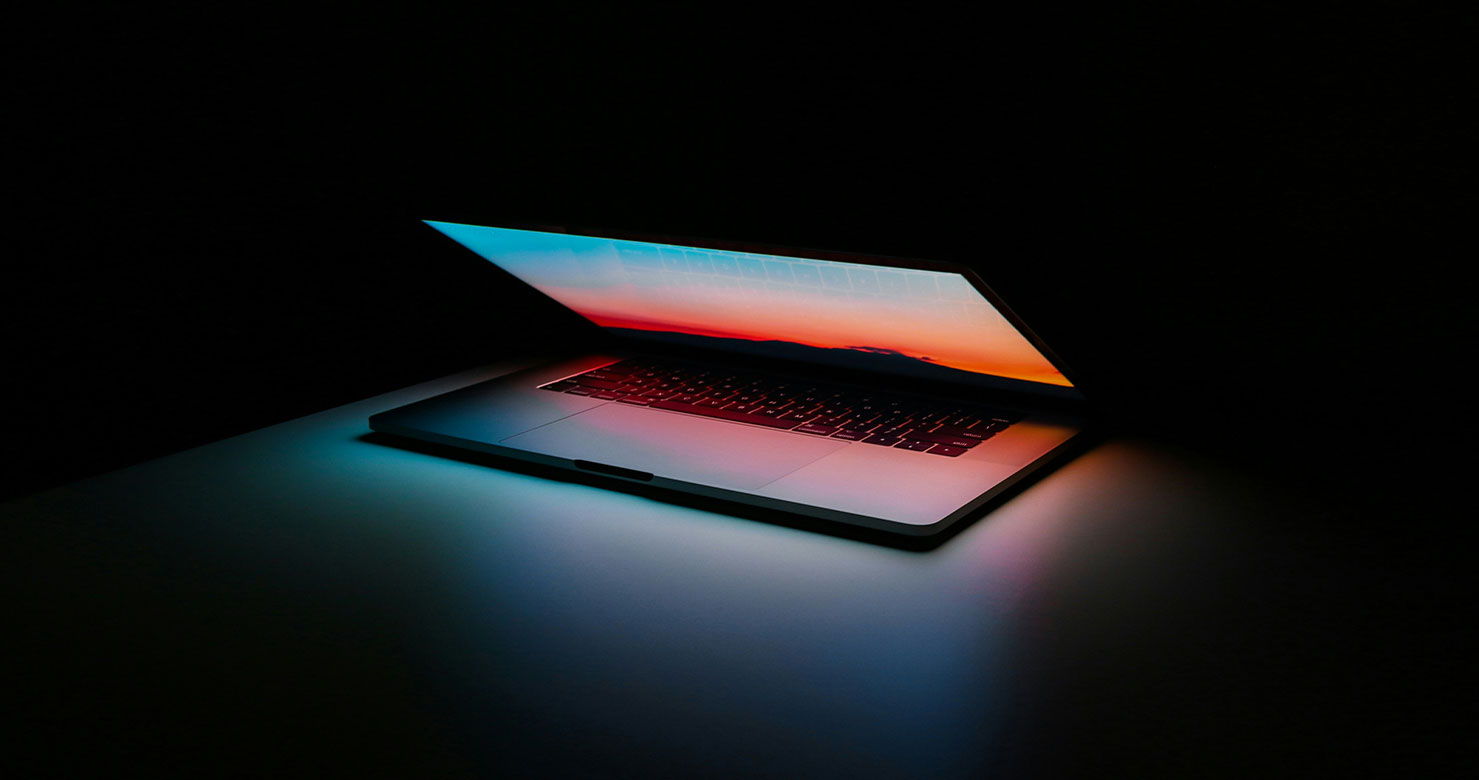 open laptop glowing on dark background