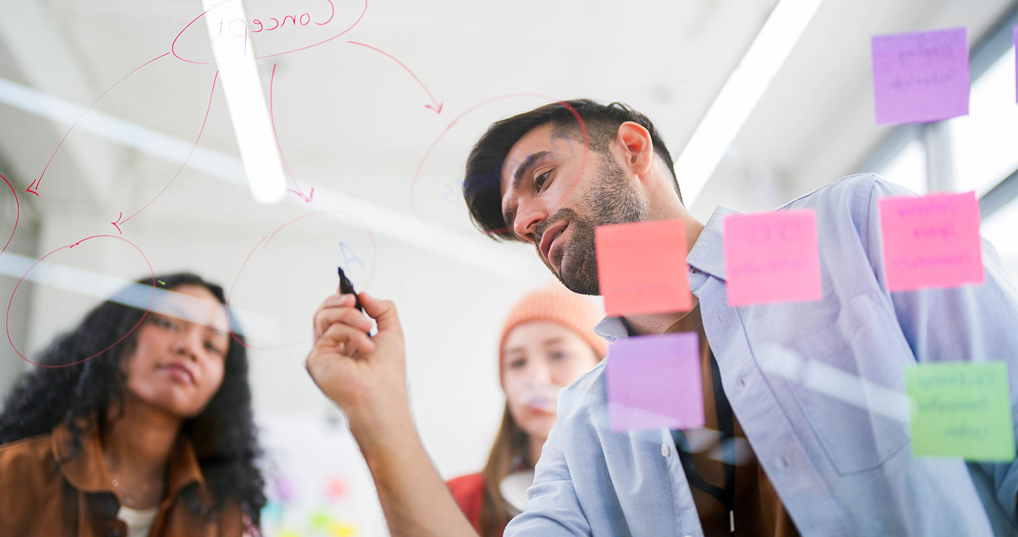 Dynamic brainstorming session with a focused team using a transparent idea board to strategize in the office.